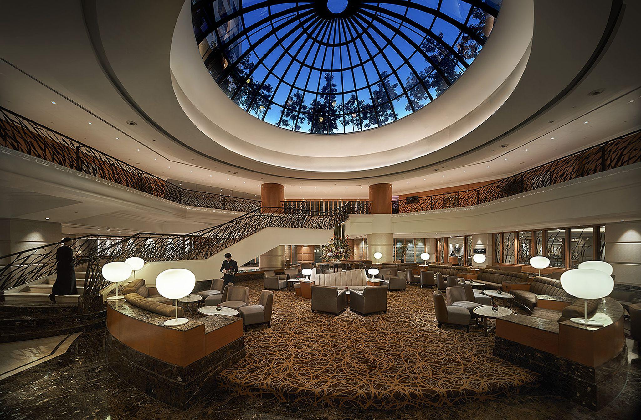 Sunway Putra Hotel Kuala Lumpur Exterior photo The photo shows a luxurious interior of a hotel or a high-end lounge area. It features a spacious layout with a grand staircase that leads to an upper level. The ceiling is dome-shaped with a large skylight that allows natural light to filter in, cre