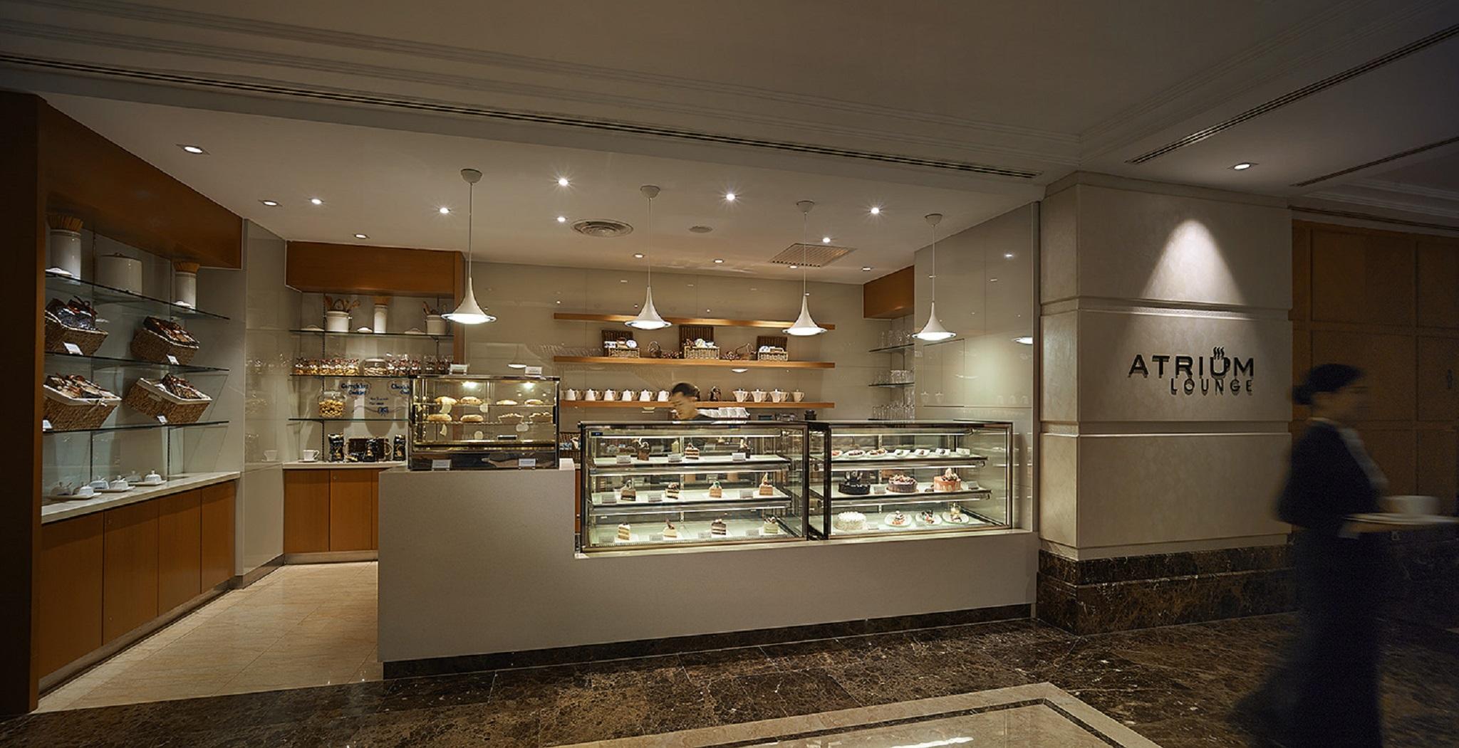 Sunway Putra Hotel Kuala Lumpur Exterior photo The photo shows the interior of a café or dessert shop named "Atrium." It features a sleek, modern design with a glass display case filled with various pastries and desserts. The area is well-lit with multiple pendant lights hanging from the ceiling,