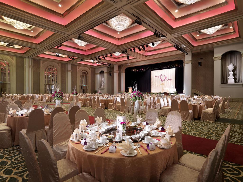 Sunway Putra Hotel Kuala Lumpur Exterior photo The photo depicts a large banquet hall set up for an event, likely a formal gathering or celebration. There are multiple round tables covered with elegant tablecloths and adorned with fine dining ware, including plates, cups, and decorative centerpie
